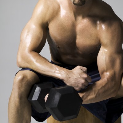 medium shot of a male bodybuilder as he lifts a weight
