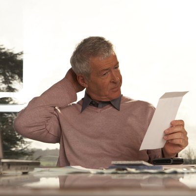 Man sitting at desk scratching head