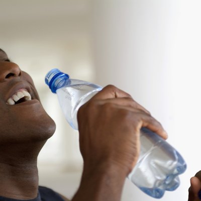 Close-up of a man drinking water from a bottle