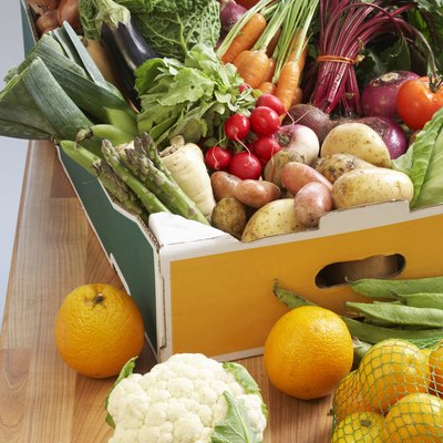 Cardboard box of assorted vegetables on kitchen counter