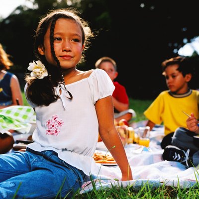 shot of a group of young children sitting on a lawn