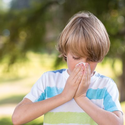 Little boy blowing his nose
