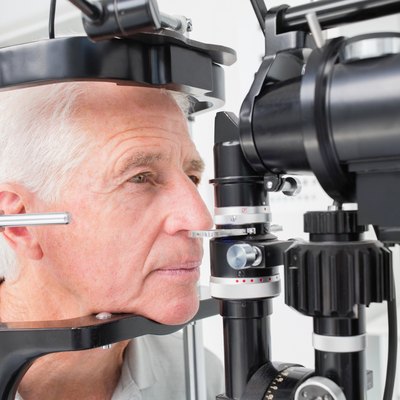 Man looking into slit lamp