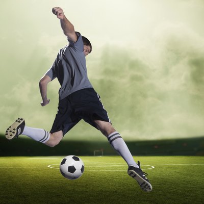 Soccer player kicking the ball in a stadium, green sky with clouds