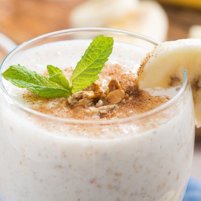 milkshake with banana, granola and cinnamon in a glass, close-up