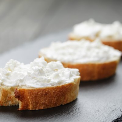 crunchy baguette slices with cream cheese on slate board