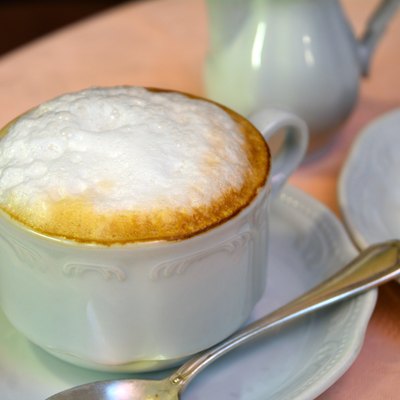 Delicious cappuccino on a white cup on a table