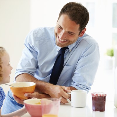 Father And Daughter Having Breakfast In Kitchen Together