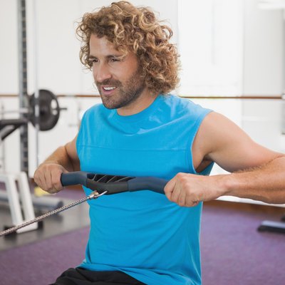 Handsome man using resistance band in gym