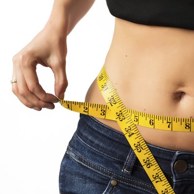 Woman measuring her waistline