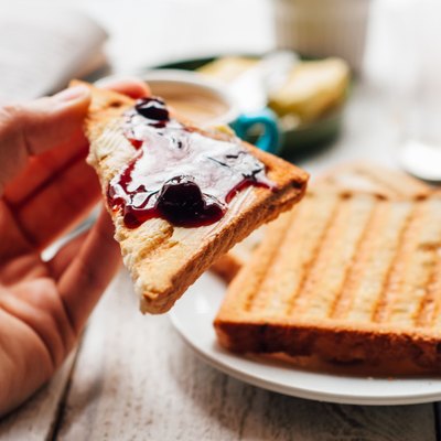Woman hand eating toast for breakfast