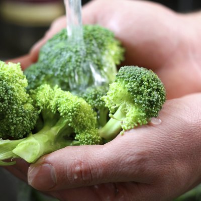 Man's Hands Washing Broccoli Vegetables in Kitchen Sink