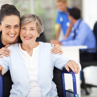 adult daughter accompanying senior mother visiting doctor