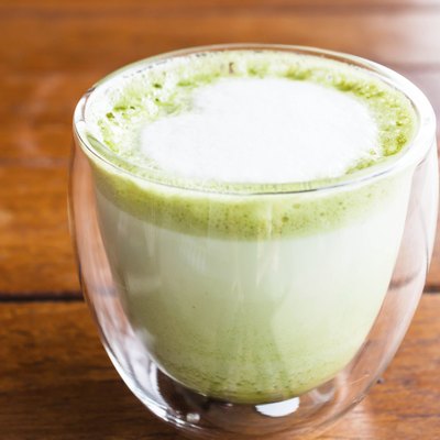 Hot matcha green tea latte glass with milk microfoam