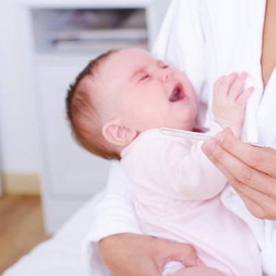 Screaming baby with thermometer