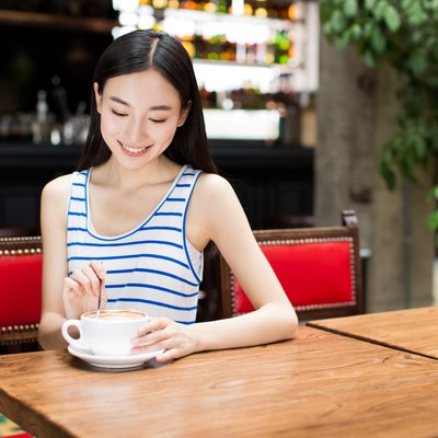 young girl at a cafe drinking coffee