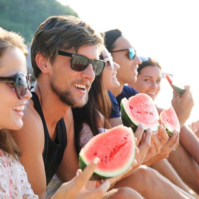 Friends eating watermelon on beach
