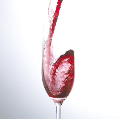 Red Wine Being Poured Into a Champagne Flute