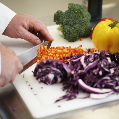 Chef chopping vegetables in kitchen, close-up