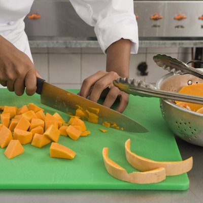 Chef cutting squash in kitchen