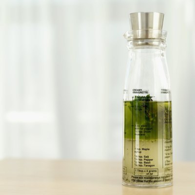 Close-up of a bottle of herbs in olive oil