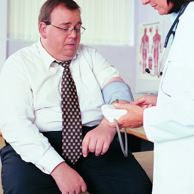 Overweight Businessman Having his Blood Pressure Taken by a Doctor