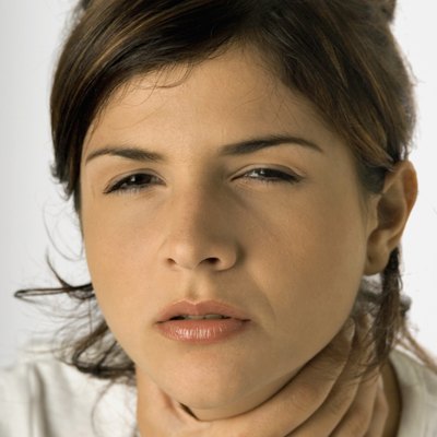 Woman with sore throat and hand on throat, close-up