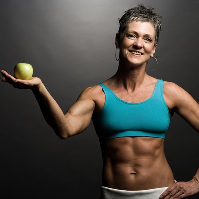Body builder holding an apple
