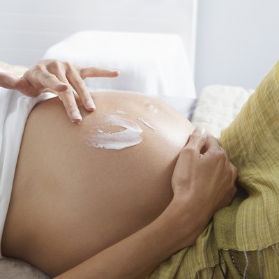 Pregnant Woman Putting Lotion on Stomach