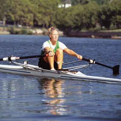Young woman rowing scull on water
