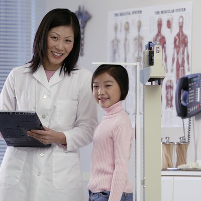 Healthcare worker measuring girl's height