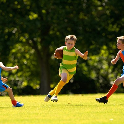 Young player avoids a tackle in a football game