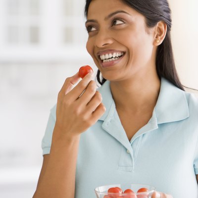 Indian woman eating tomato