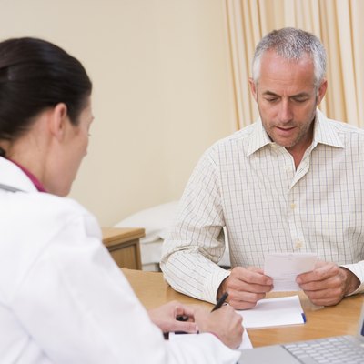 Doctor with laptop and man in doctor's office