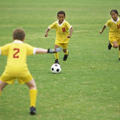 two boys and a girl playing soccer