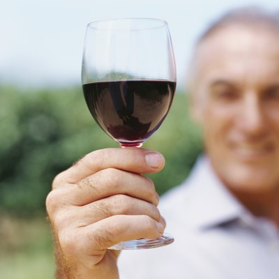 mature man showing a glass of red wine