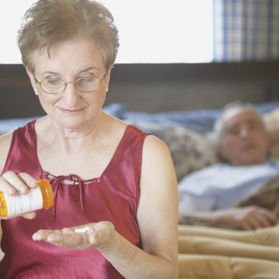 Senior woman holding a bottle of pills