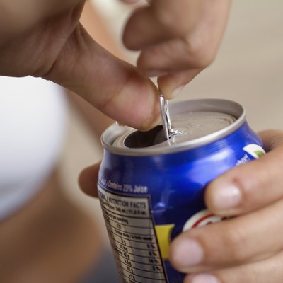 Extreme close-up of woman opening canned drink, focus on foreground