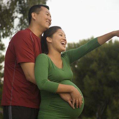 Pregnant Asian couple hugging