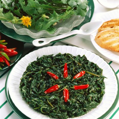 high angle view of a side dish of green garnished with chilies and served with salad and bread