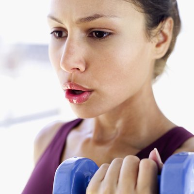 Close-up of a young woman lifting a dumbbell
