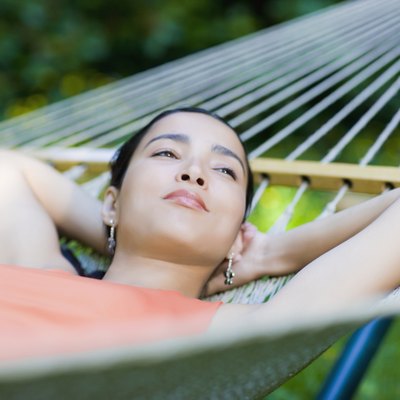 Hispanic woman laying in hammock