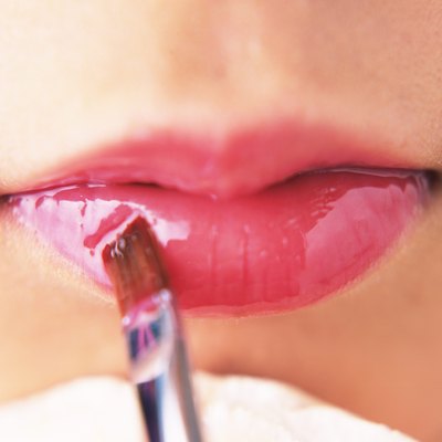 A Woman Applying Pink-Colored Lip Gloss, Front View, Differential Focus