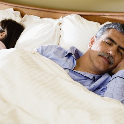 Middle-aged couple sleeping in bed