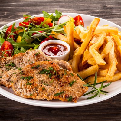 Grilled steaks, French fries and vegetables
