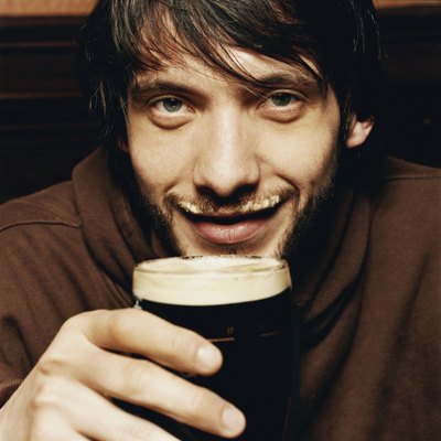 Young Man Enjoying a Drink of Stout in a Pub