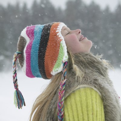 Girl (8-10) on slope, smiling with head back, close-up, side view