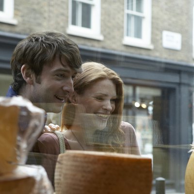 Young couple looking in store window, view from inside store