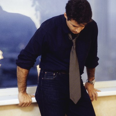 Man leaning against window sill, three quarter length