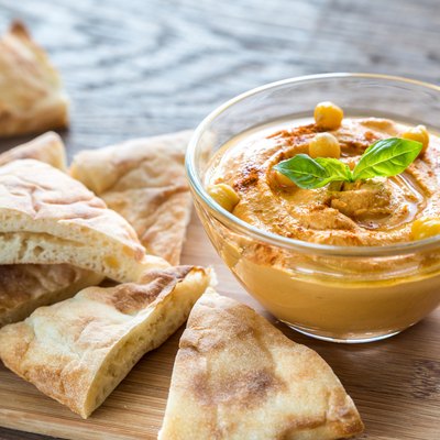 Bowl of hummus with pita slices